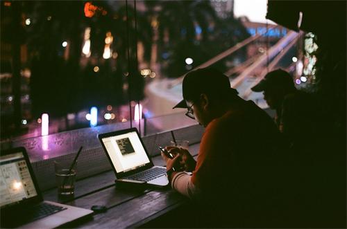 People working on laptops and phones at night cafe