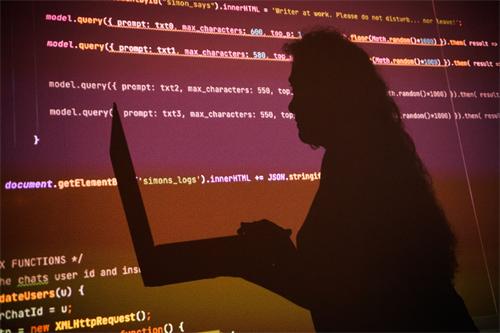 Silhouette of a person using a laptop in front of glowing AIJavaScript code on a screen